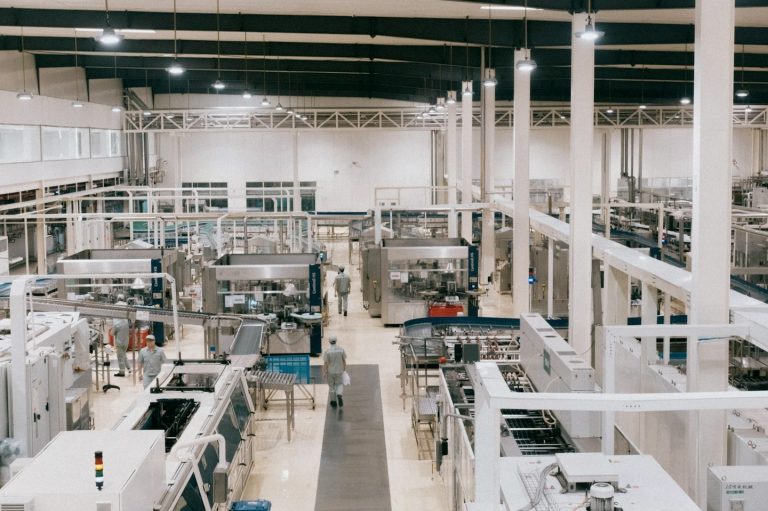 Industrielle Fertigungsanlage mit Maschinen und Anlagen in einem großen, hellen Raum.